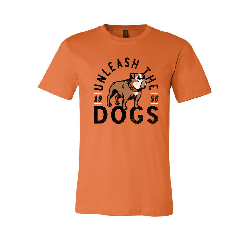 Orange graphic T-shirt displaying the words "unleash the dogs" and "1956 in black lettering surrounding graphic of bulldog