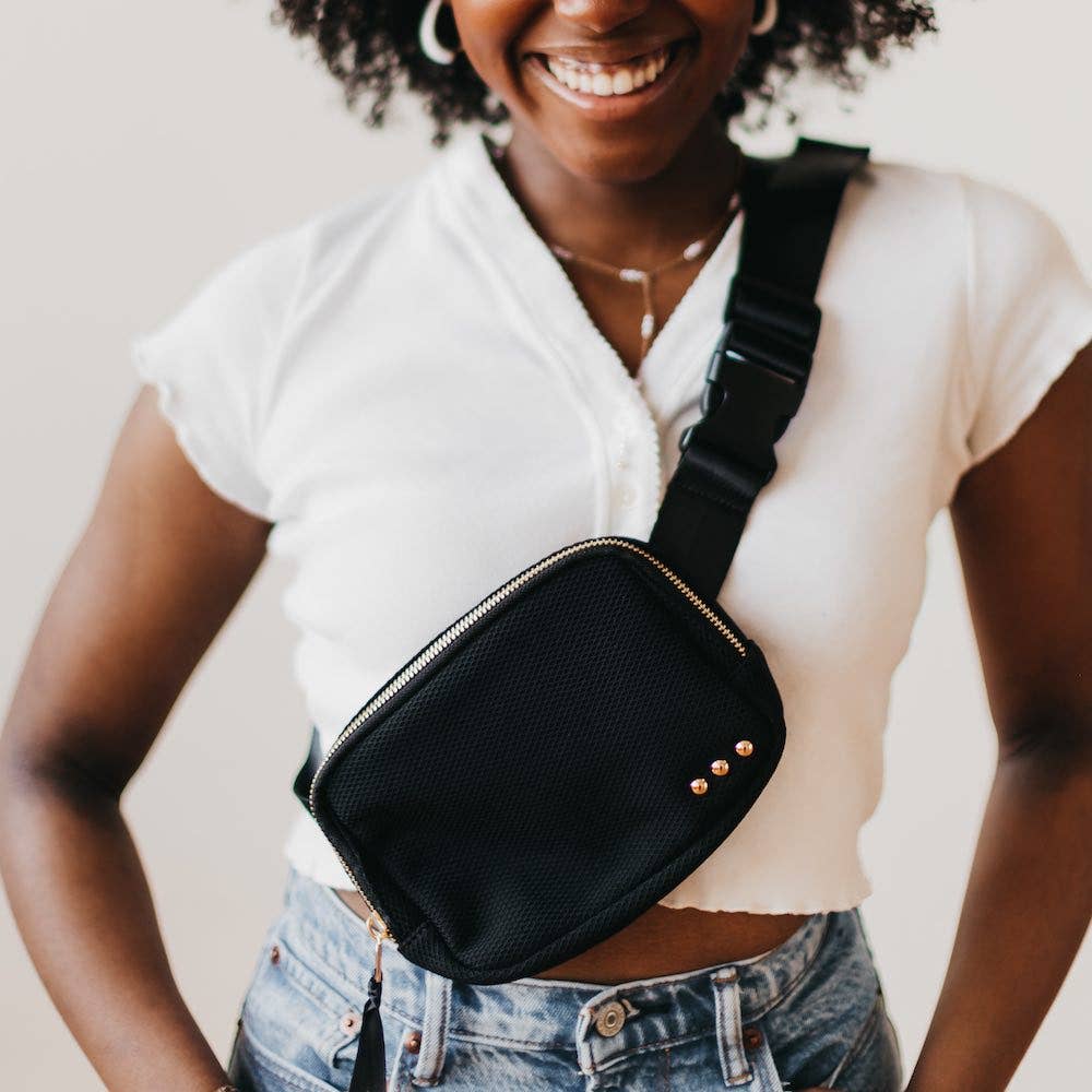 African American woman in cropped white top wearing a small black Brooklyn Bum Bag with three gold studs adjustable strap